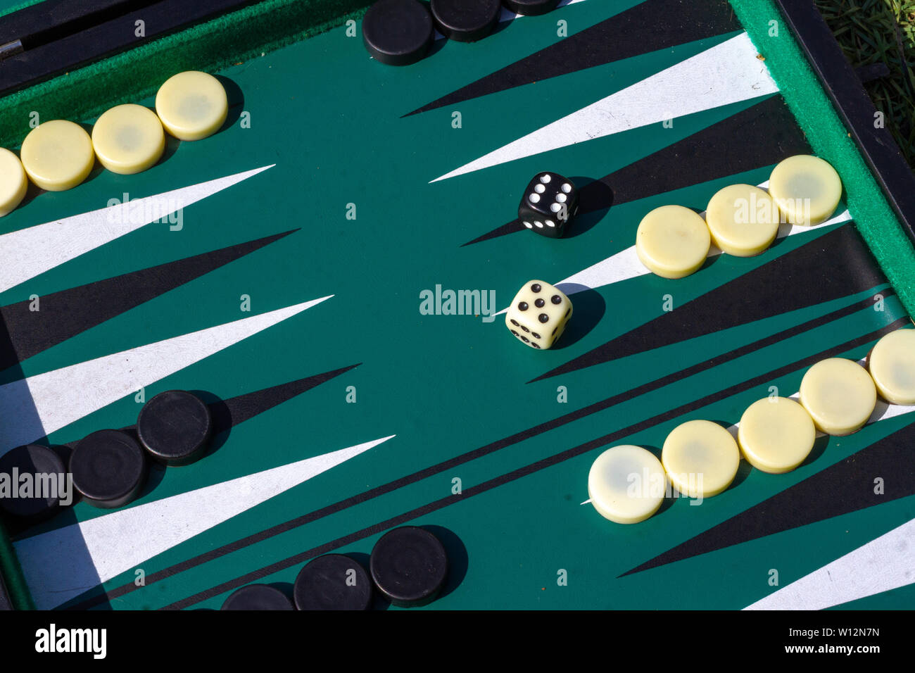Jeu de backgammon avec la configuration de démarrage et deux dés, un blanc, un noir montrant un six et un cinq Banque D'Images