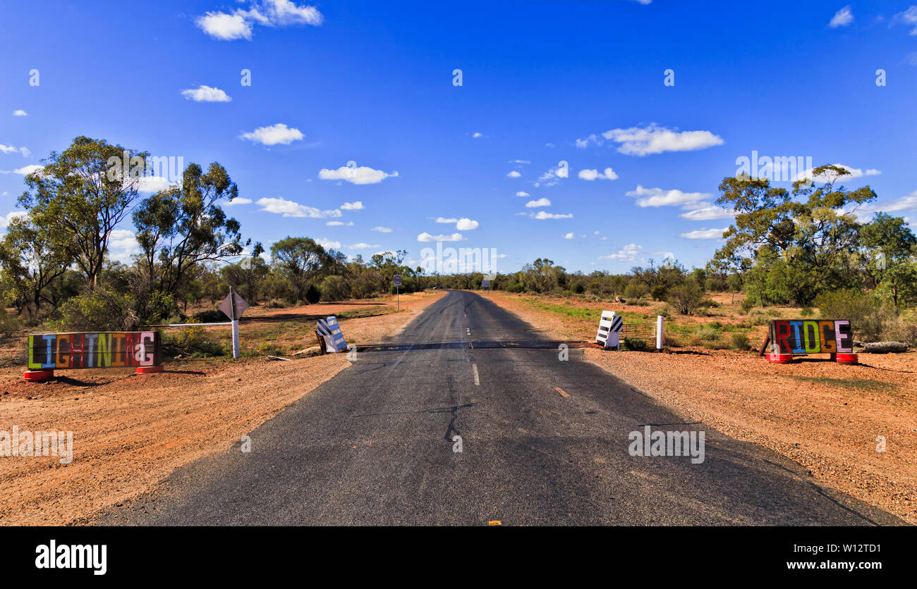 La porte d'entrée avec grille de bovins à travers le bitume route menant à Lightning Ridge mine d'opale commune à l'écart de la route dans l'outback , de l'Australie. Banque D'Images