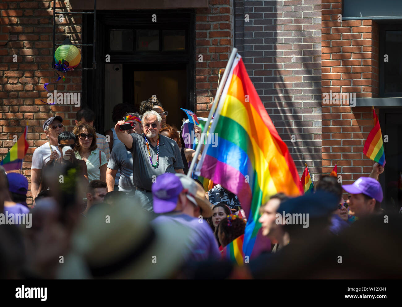 NEW YORK - 25 juin 2017 : vague Supporters drapeaux arc-en-ciel dans la Gay Pride Parade LGBTQI annuel qui passe par Greenwich Village. Banque D'Images