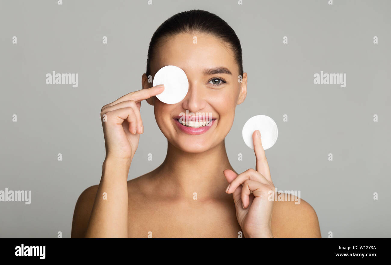 Jeune femme lave son visage avec un coton-tige les cosmétiques. Clinique.  Le nettoyage de la peau du visage avec un coton. Maquillage de lavage Photo  Stock - Alamy