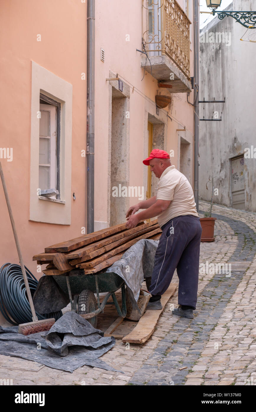 Un menuisier travaille la réparation d'un étage d'une vieille maison à Alfama, Lisbonne, Portugal Banque D'Images