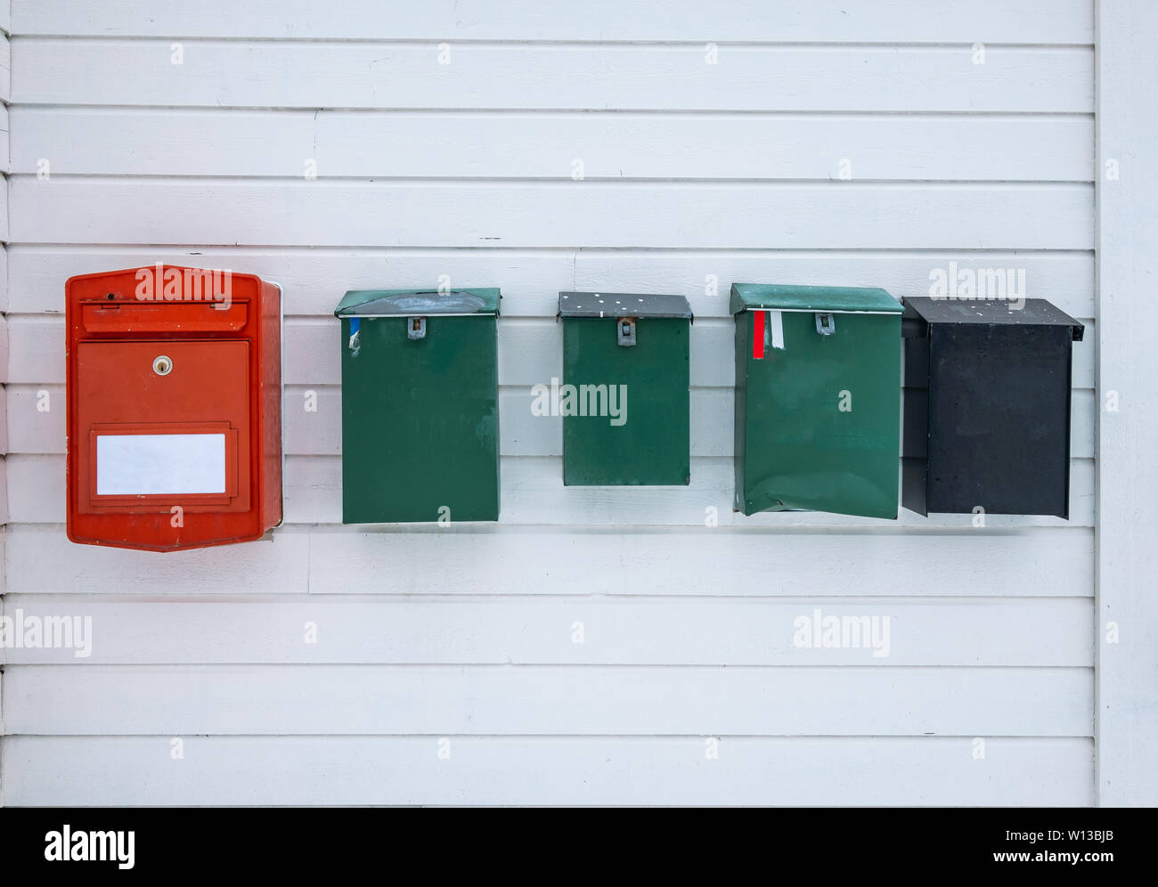 Les boîtes aux lettres des couleurs vintage sur le long mur en bois dans des pensionnats Banque D'Images