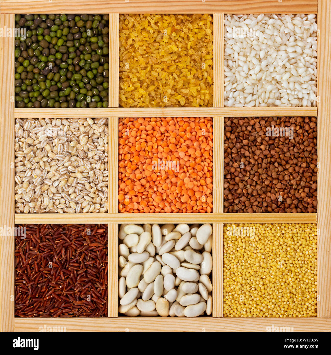 Différents types de gruaux dans boîte en bois carrés, collecte des matières les céréales, les haricots et les graines, les textures Vue de dessus Banque D'Images