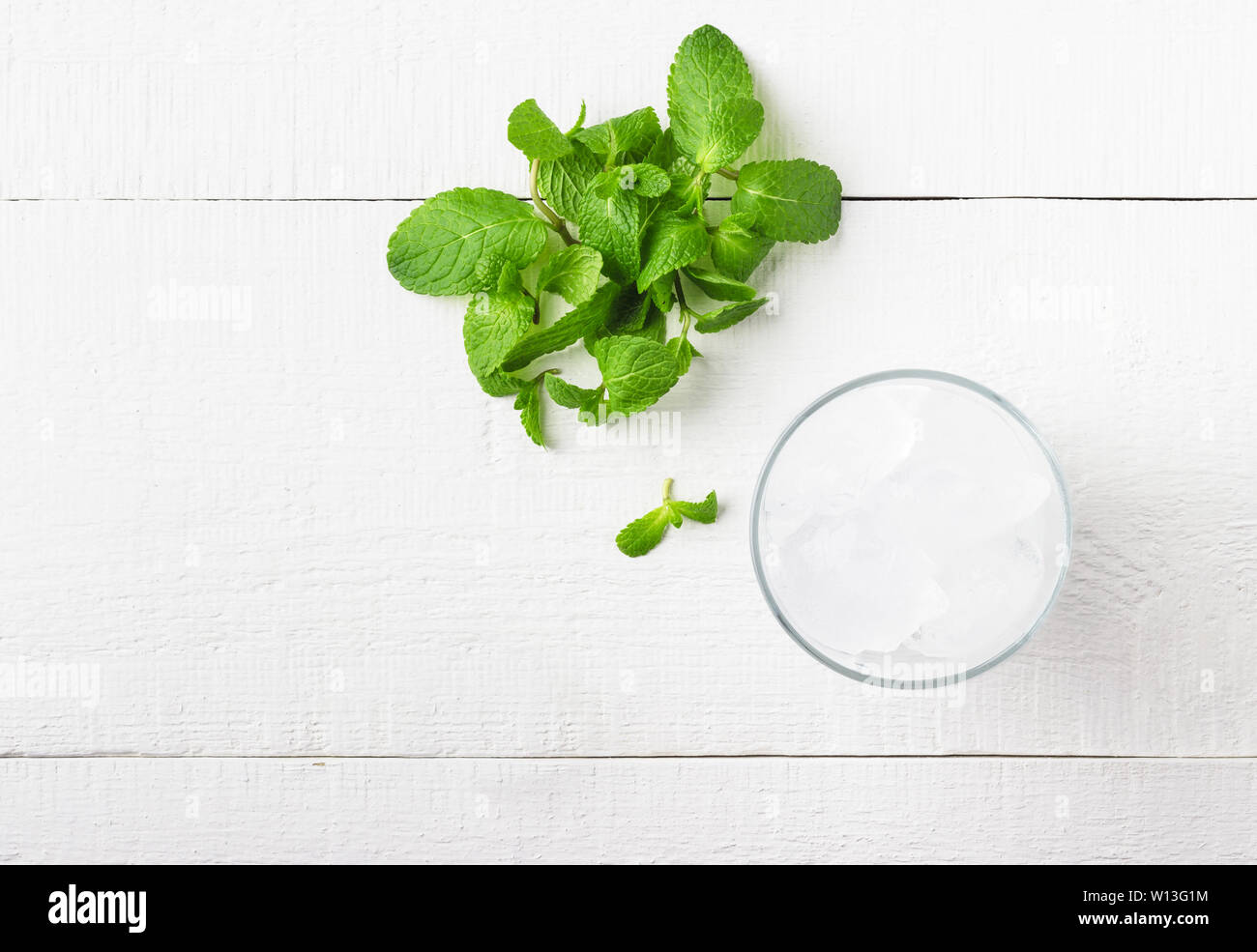 Dans un verre de glace et de menthe fraîche sur un fond de bois blanc. Vue d'en haut. Banque D'Images