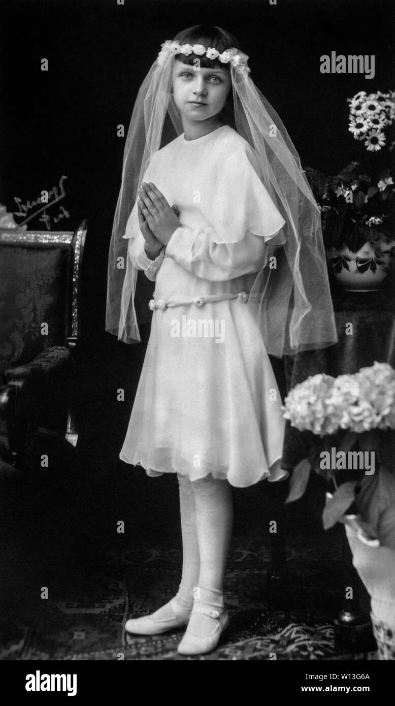 Début de portrait de studio de une jolie jeune fille pour sa première communion le port d'un voile blanc pendant la prière par le photographe hongrois Hongrie Pecs zelesny Banque D'Images