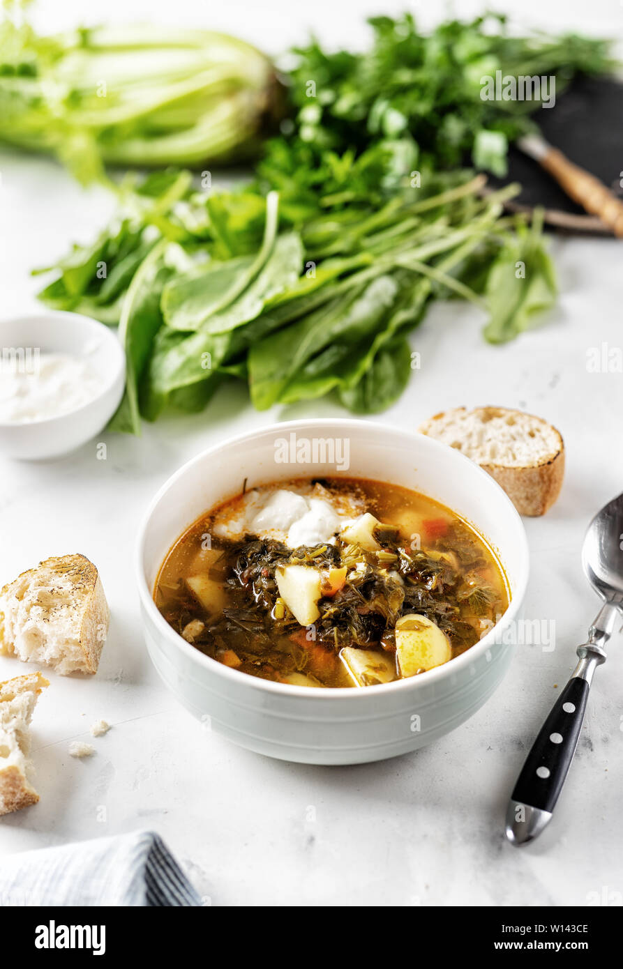 Soupe à l'oseille à la crème dans un bol blanc sur le tableau blanc Banque D'Images