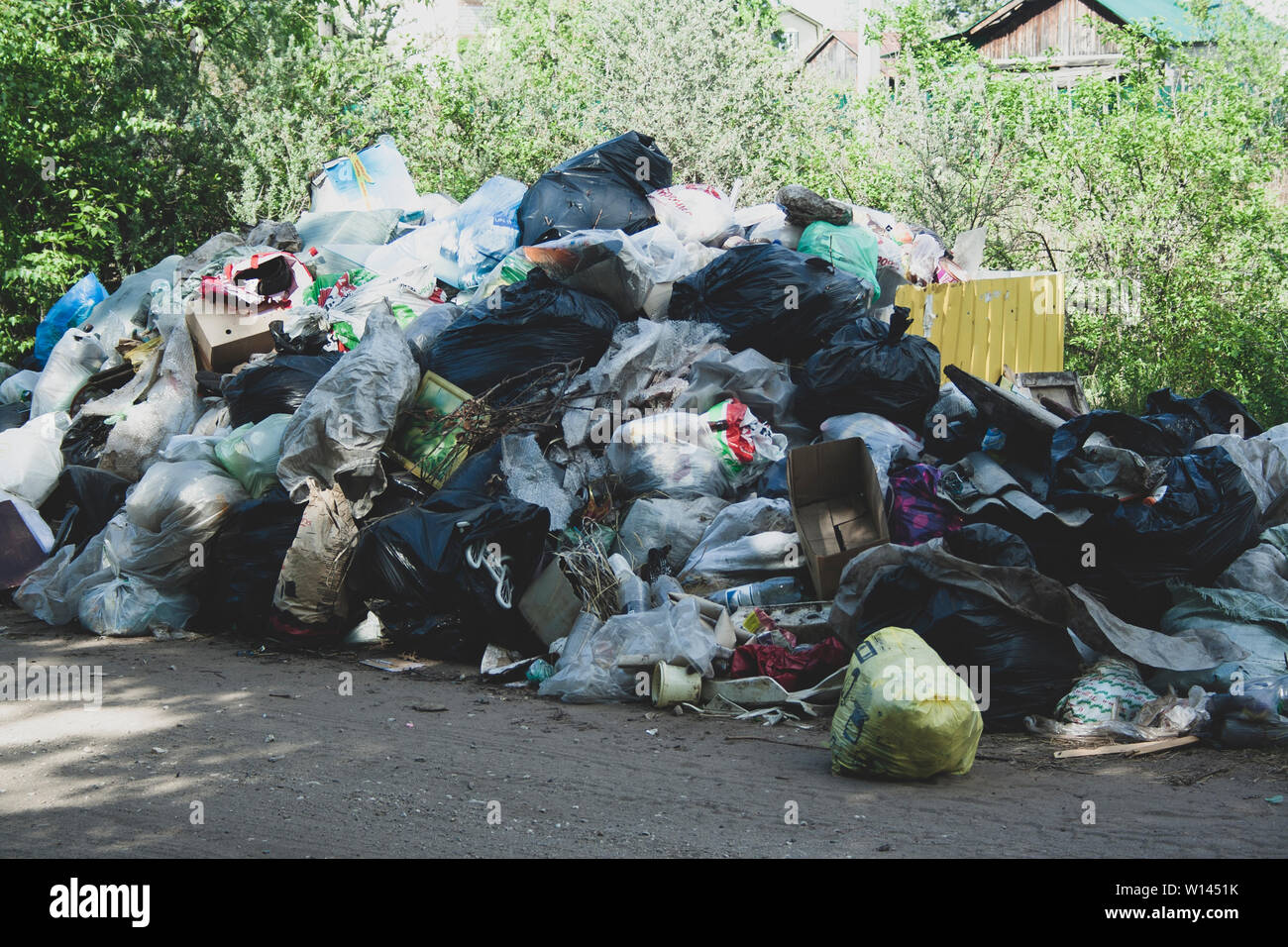 Décharge illégale près de la route de sable de pays dans le pays le jour de soleil. Corbeille de la pollution dans la nature. Pays dépotoir près de Sales Banque D'Images