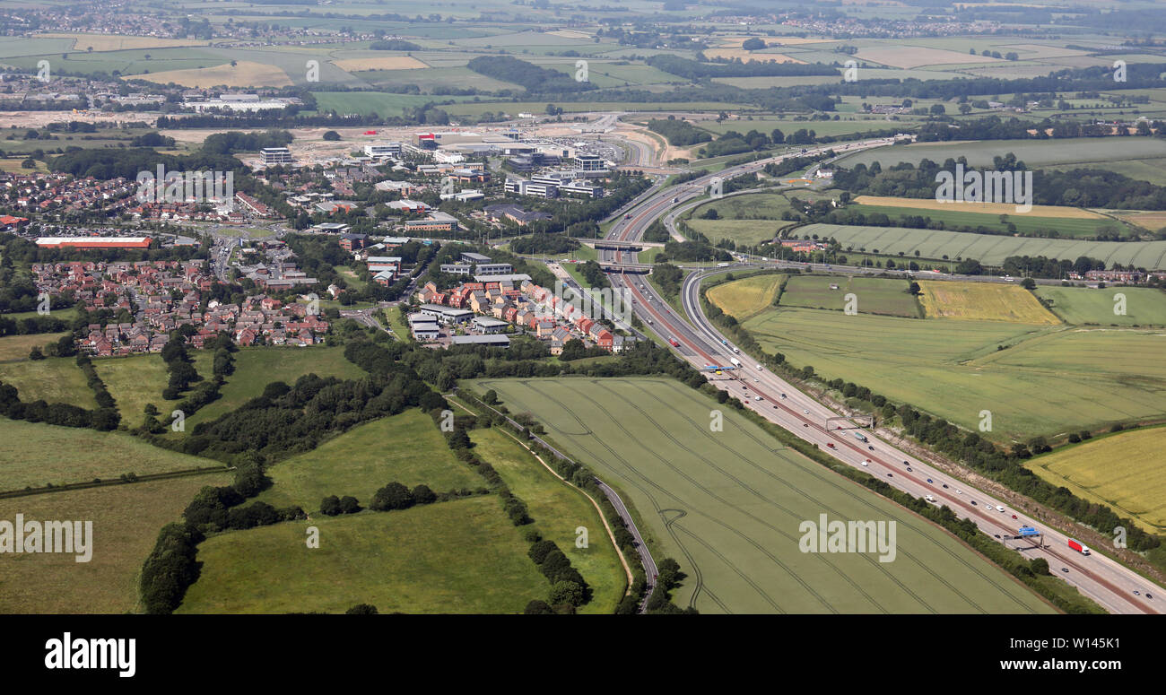 Vue aérienne de l'autoroute M1 en direction du nord vers la sortie 46 Leeds Thorpe Park, y compris Colton Retail Park et Austhorpe, Leeds, West Yorkshire 15 Banque D'Images