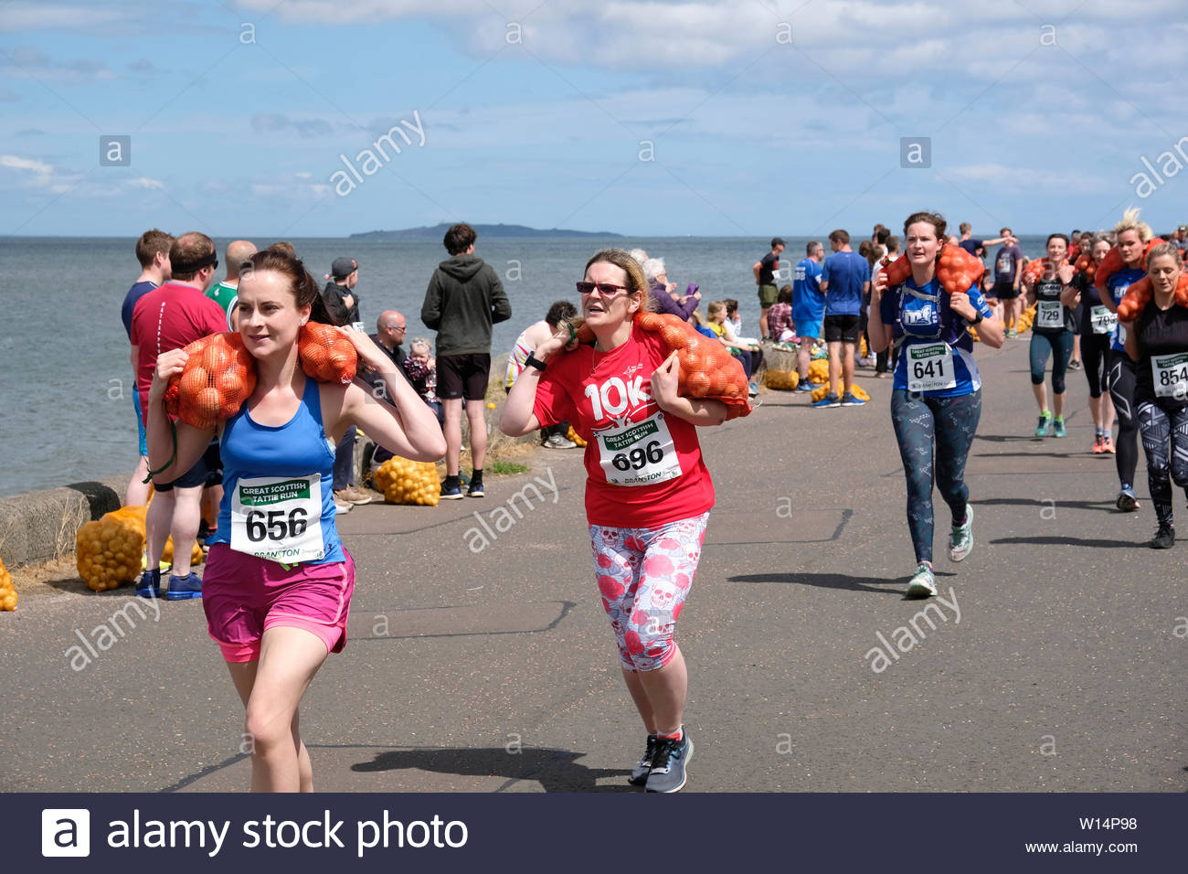 Edinburgh, Ecosse, Royaume-Uni. 30 juin 2019. Le Grand Scottish Tattie fonctionner à Silverknowes Promenade, organisée par de grands événements écossais, un événement de collecte de fonds du groupe organisateur. La course est d'un mille avec un sac de pommes de 20 kilo pour les hommes,10 kilos pour les femmes. Tous les participants obtiennent de garder leur sac de tatties. Credit:Craig Brown Banque D'Images