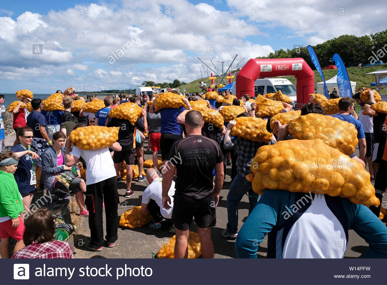 Edinburgh, Ecosse, Royaume-Uni. 30 juin 2019. Les participants avec leur sac de collecte tatties avant la compétition dans le Grand Scottish Tattie fonctionner à Silverknowes Promenade, organisée par de grands événements écossais, un événement de collecte de fonds du groupe organisateur. La course est d'un mille avec un sac de pommes de 20 kilo pour les hommes,10 kilos pour les femmes. Tous les participants obtiennent de garder leur sac de tatties. Credit:Craig Brown Banque D'Images