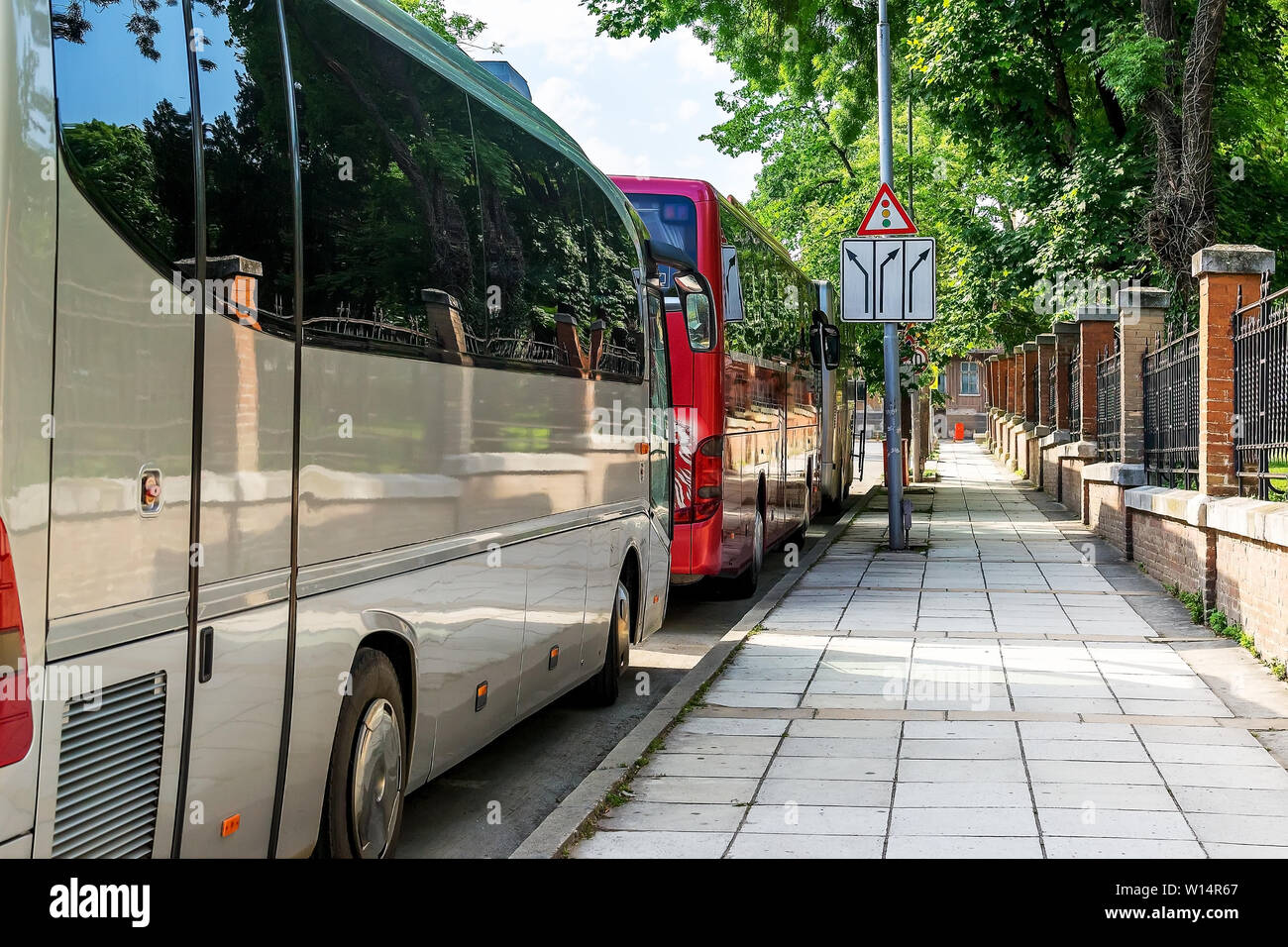 Trois autobus touristique moderne sur une rue de la ville sur une journée ensoleillée. Les autobus sont en attente pour les touristes dans une rue latérale près du musée. Tourisme et Voyage Banque D'Images
