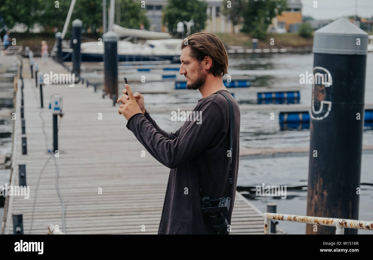 Photographe hipster élégant dans une grande ville avec un appareil photo et un sac à dos sur son dos. Banque D'Images