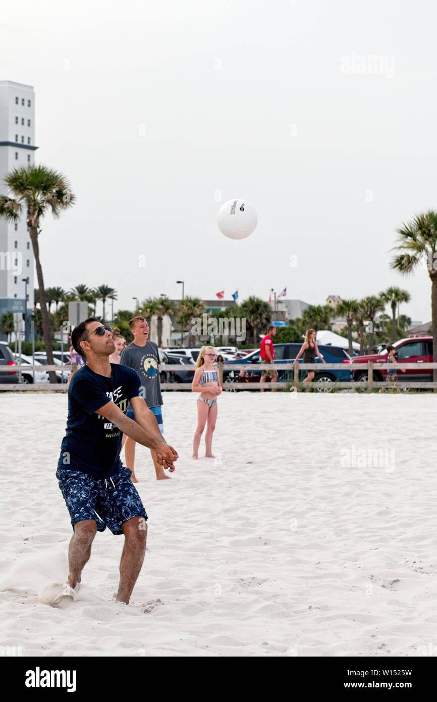 Les hommes et les femmes jouent au volley-ball sur la plage de sable Banque D'Images