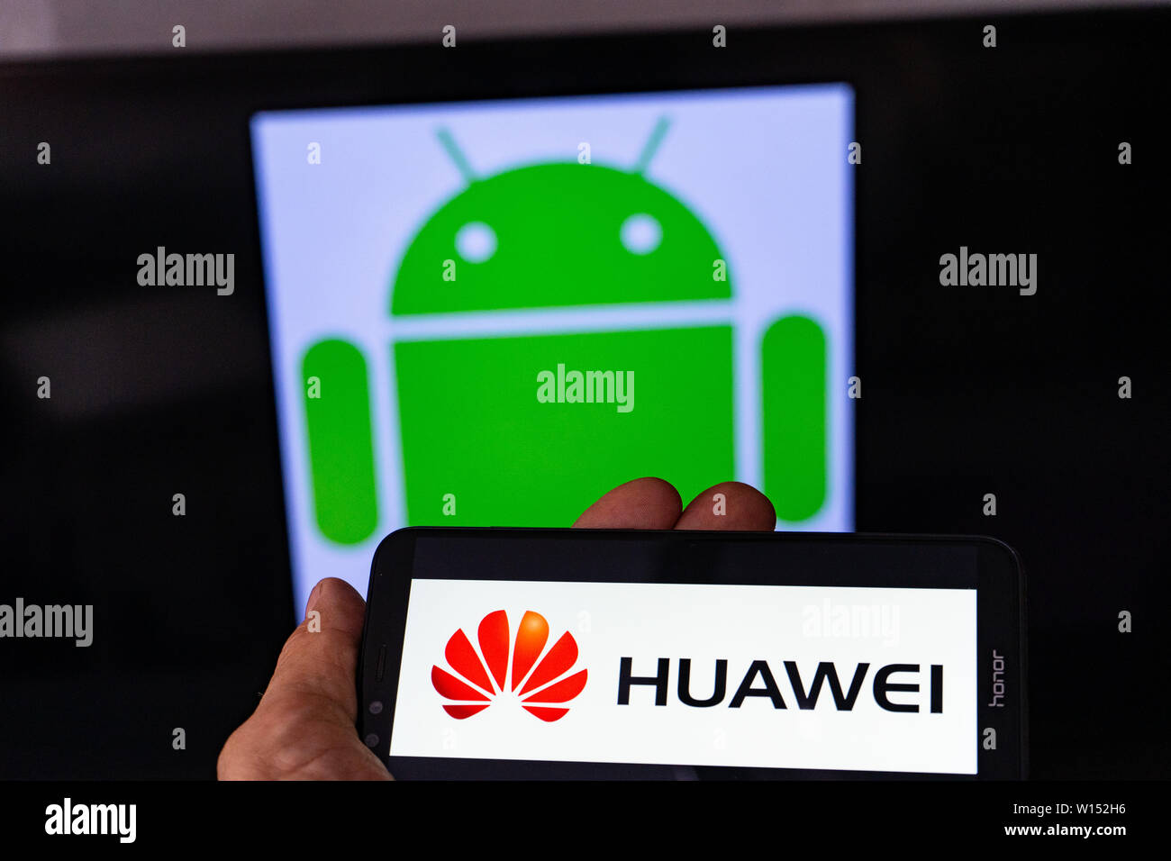Magdeburg ALLEMAGNE - Juin 2019 : un homme tenant un smartphone Android l'honneur. Sur l'écran, le logo de Huawei en face de l'Android logo. Google limiter Banque D'Images