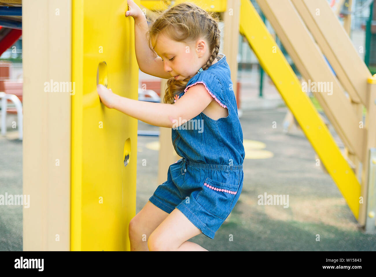 Petite fille active sur l'aire de jeux Banque D'Images