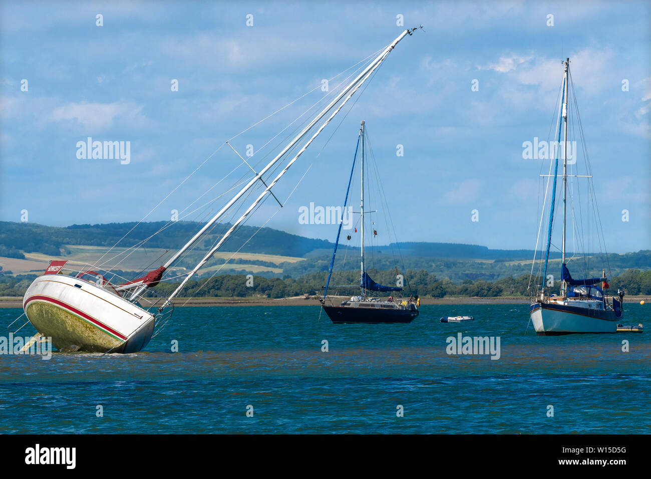 Yacht échoué au large de la tête de l'Est avec les South Downs dans le fond dans le port de Chichester, West Sussex, England, UK Banque D'Images