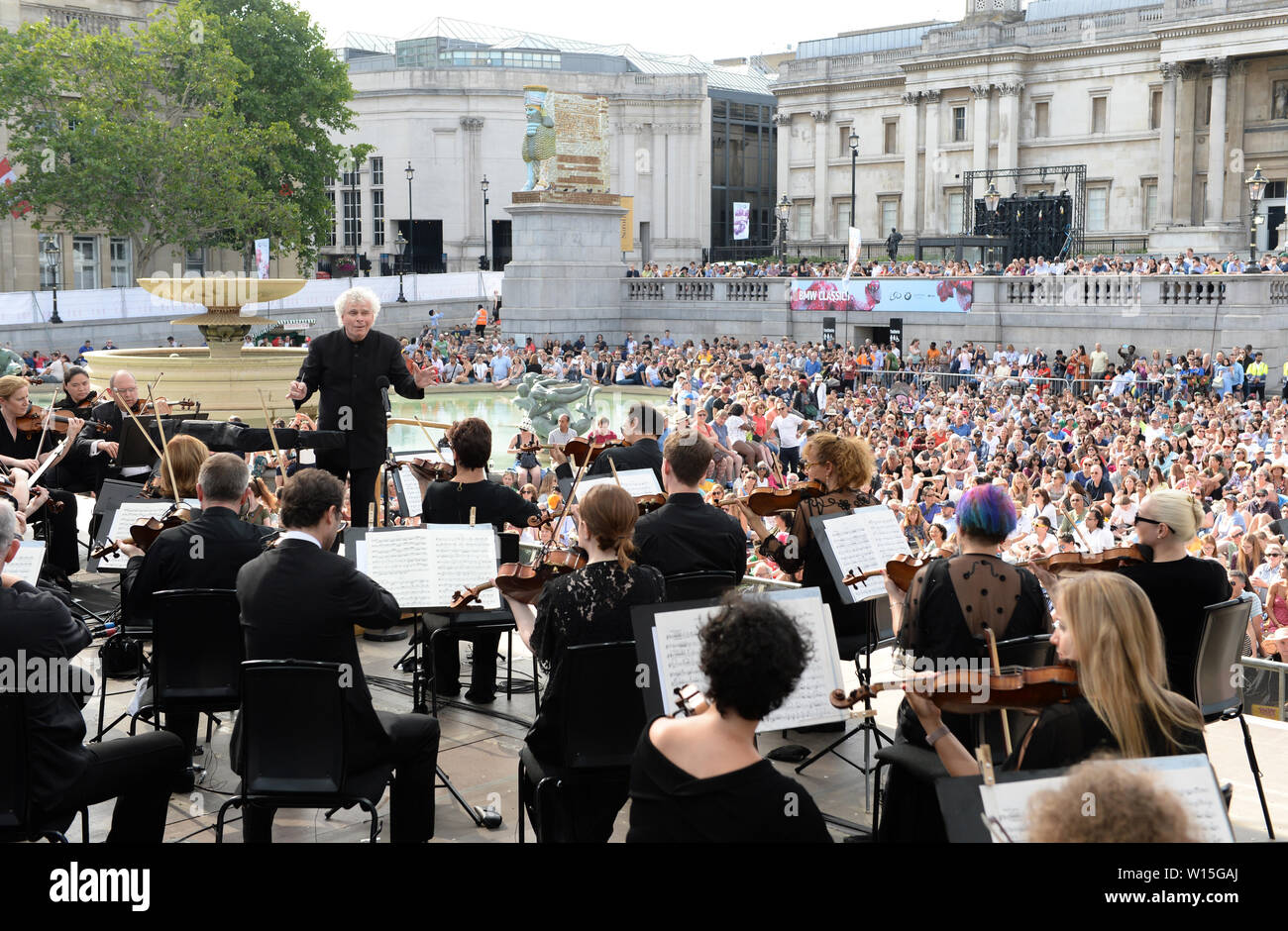 Sir Simon Rattle dirige le London Symphony Orchestra avec des musiciens âgés de 8 à 18 ans de la Guildhall School of Music & Drama et de jeunes musiciens du programme LSO On Track à l'événement BMW Classic à Trafalgar Square Londres. Banque D'Images