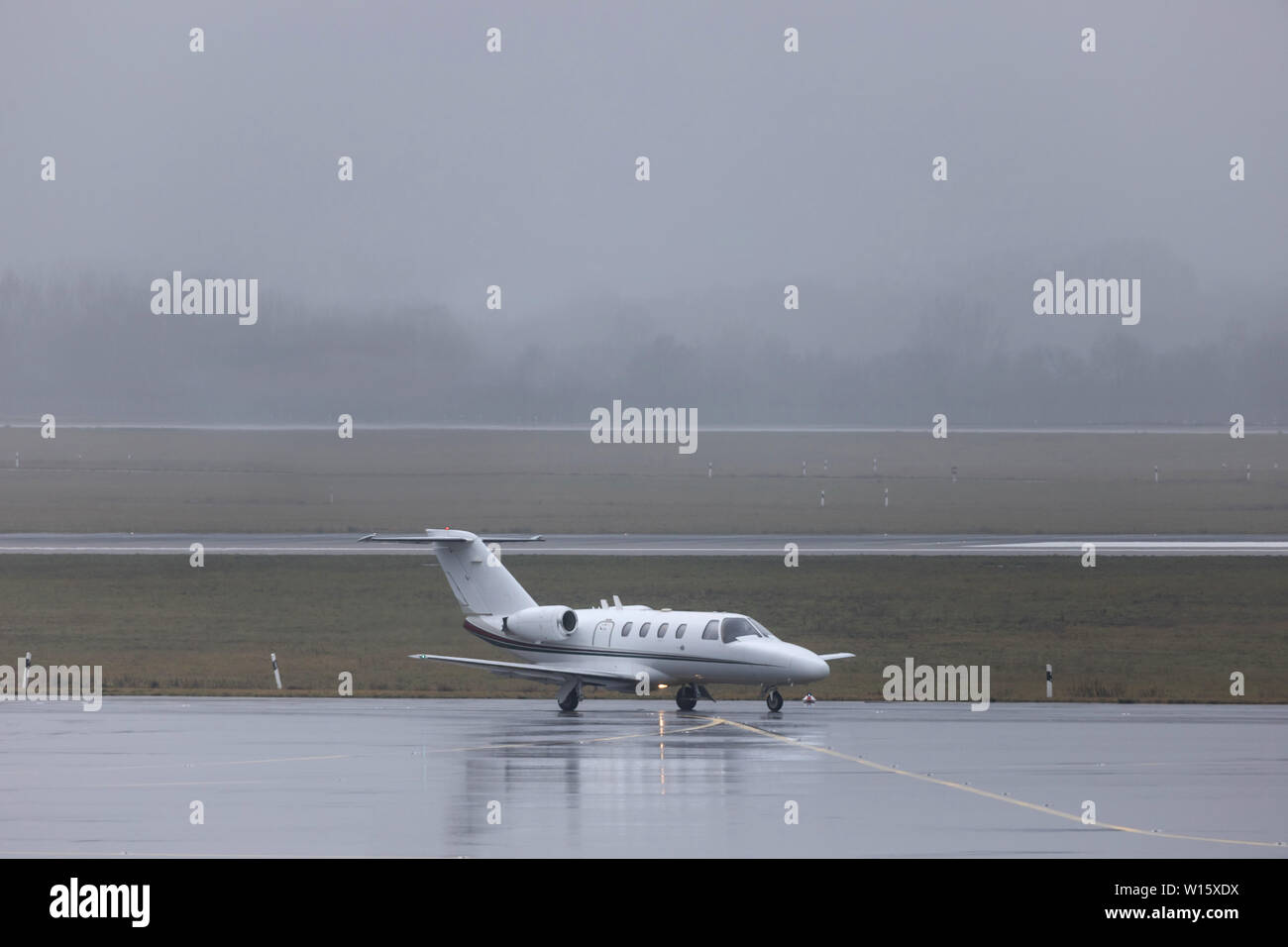 Un jet privé sur un aéroport des pluies Banque D'Images