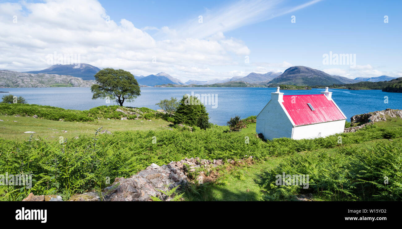 Cottage blanc au toit rouge sur le Loch Sheildaig à l'ensemble de la montagne de Torridon sur la côte nord, route 500, côte ouest des Highlands, Ecosse Banque D'Images