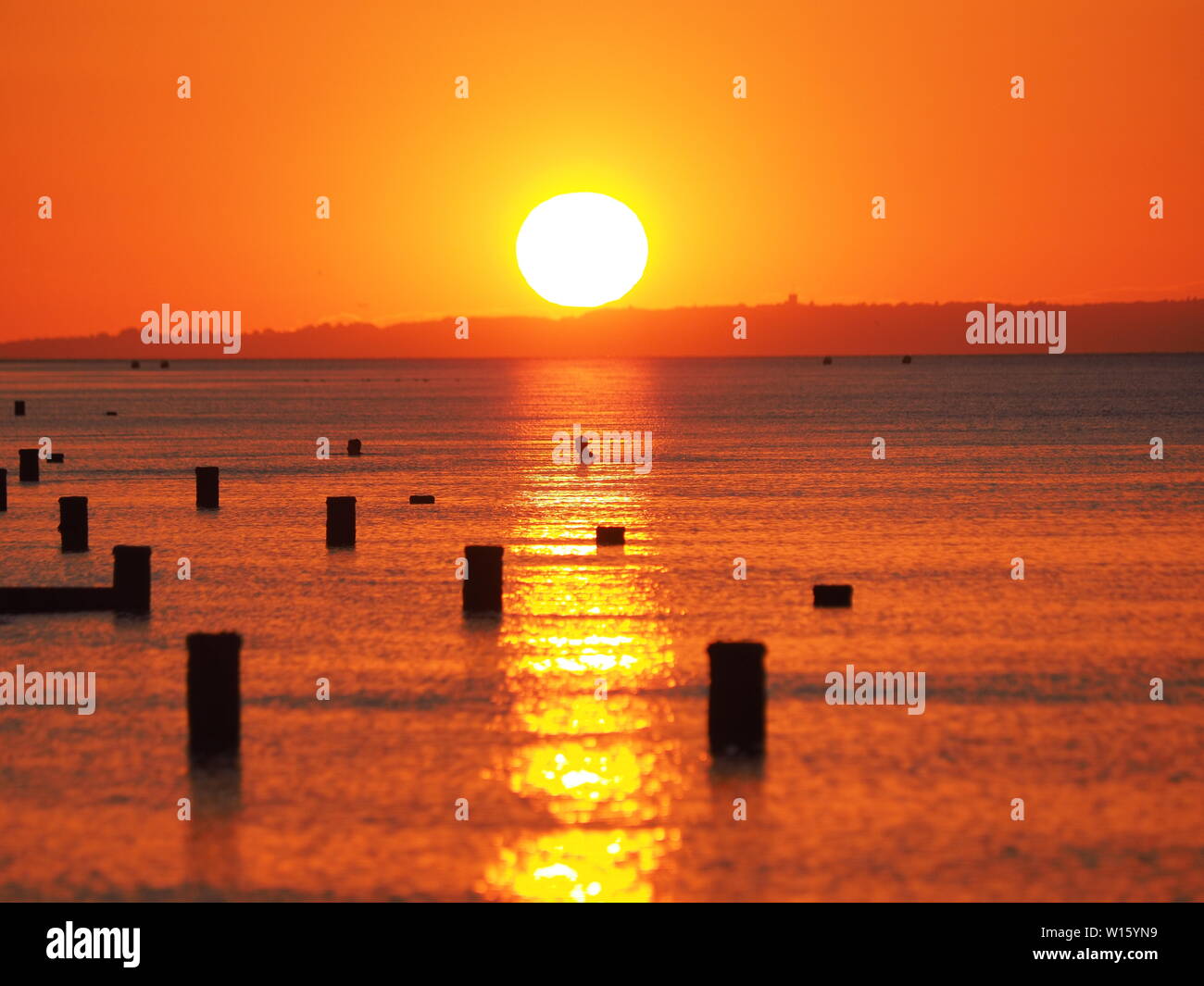 Minster sur Mer, Kent, UK. 30 Juin, 2019. Météo France : un nageur est découpé par le coucher de soleil à Minster sur Mer, Kent à la fin de journée chaude et humide. Credit : James Bell/Alamy Live News Banque D'Images