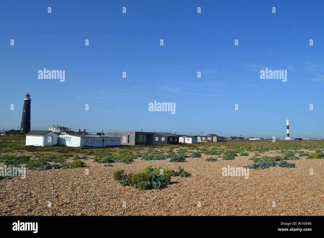 Phares et des baraques à Dungeness, Kent, sur un jour au début de l'été ensoleillé Banque D'Images