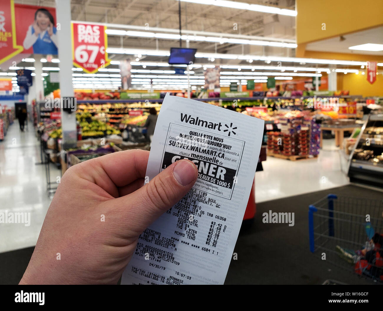 Montréal, Canada - 30 avril 2019 : Une main tenant un magasin Walmart Walmart en réception. Walmart est une société de vente au détail américaines qui exploite une chaîne Banque D'Images