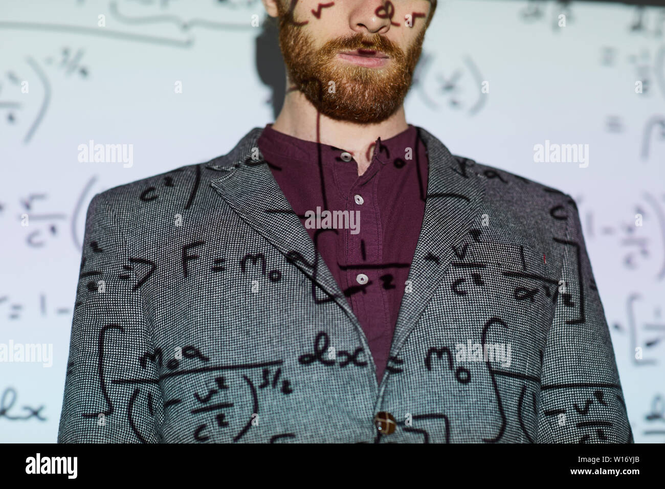 Homme barbu en veste gris debout contre l'écran de projection l'affichage des calculs mathématiques, copy space Banque D'Images
