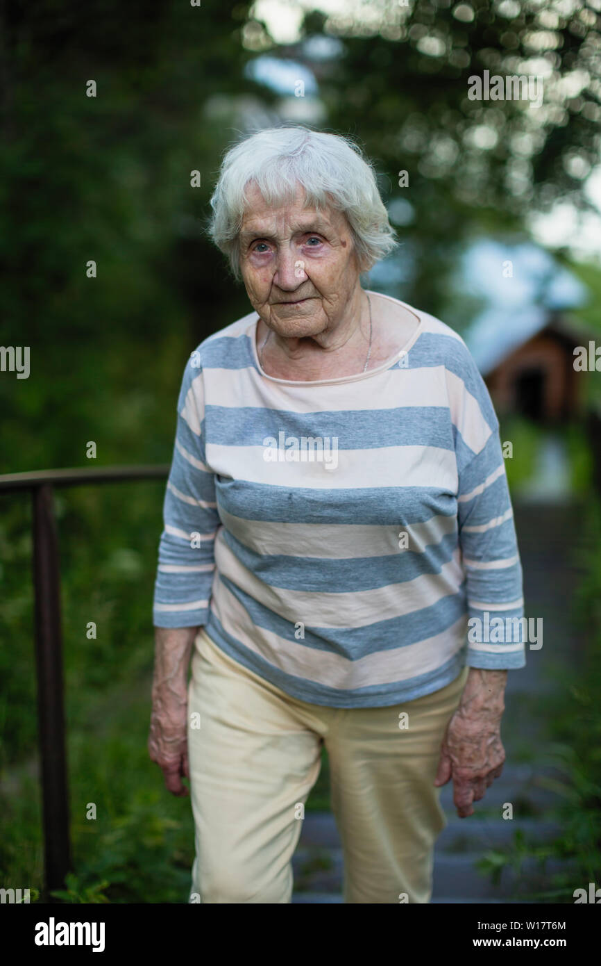 Portrait de femme âgée promenades dans un parc d'été. Banque D'Images