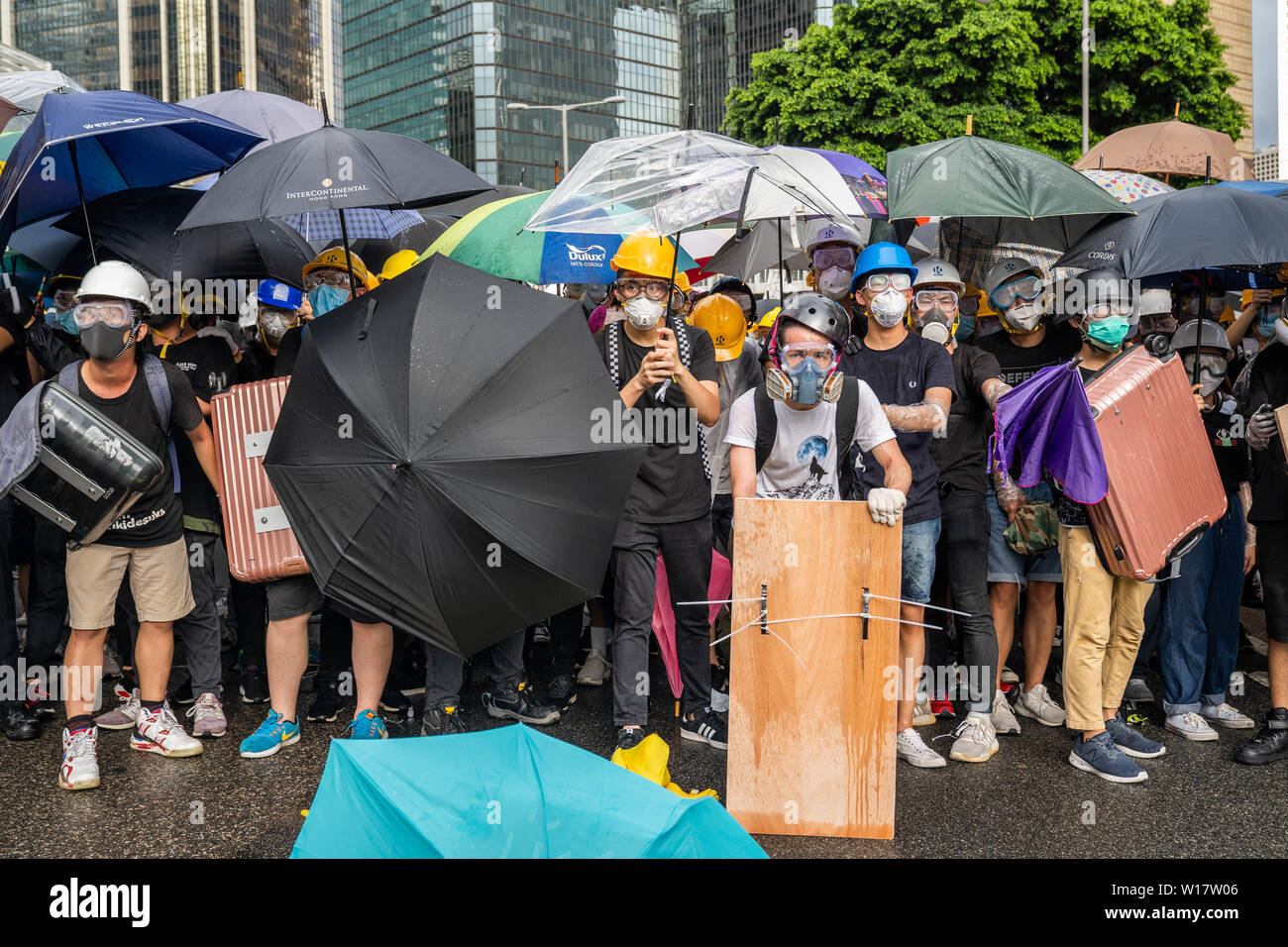 Des manifestants anti gouvernement à l'aide de parasols et de bouclier pour se protéger de la police au cours de l'impasse. Des milliers de manifestants anti-gouvernement s'affrontent avec la police anti-émeute et occuper les routes principales autour de la complexe du gouvernement de Hong Kong pendant le 22e anniversaire du retour de Hong Kong à la Chine. Banque D'Images