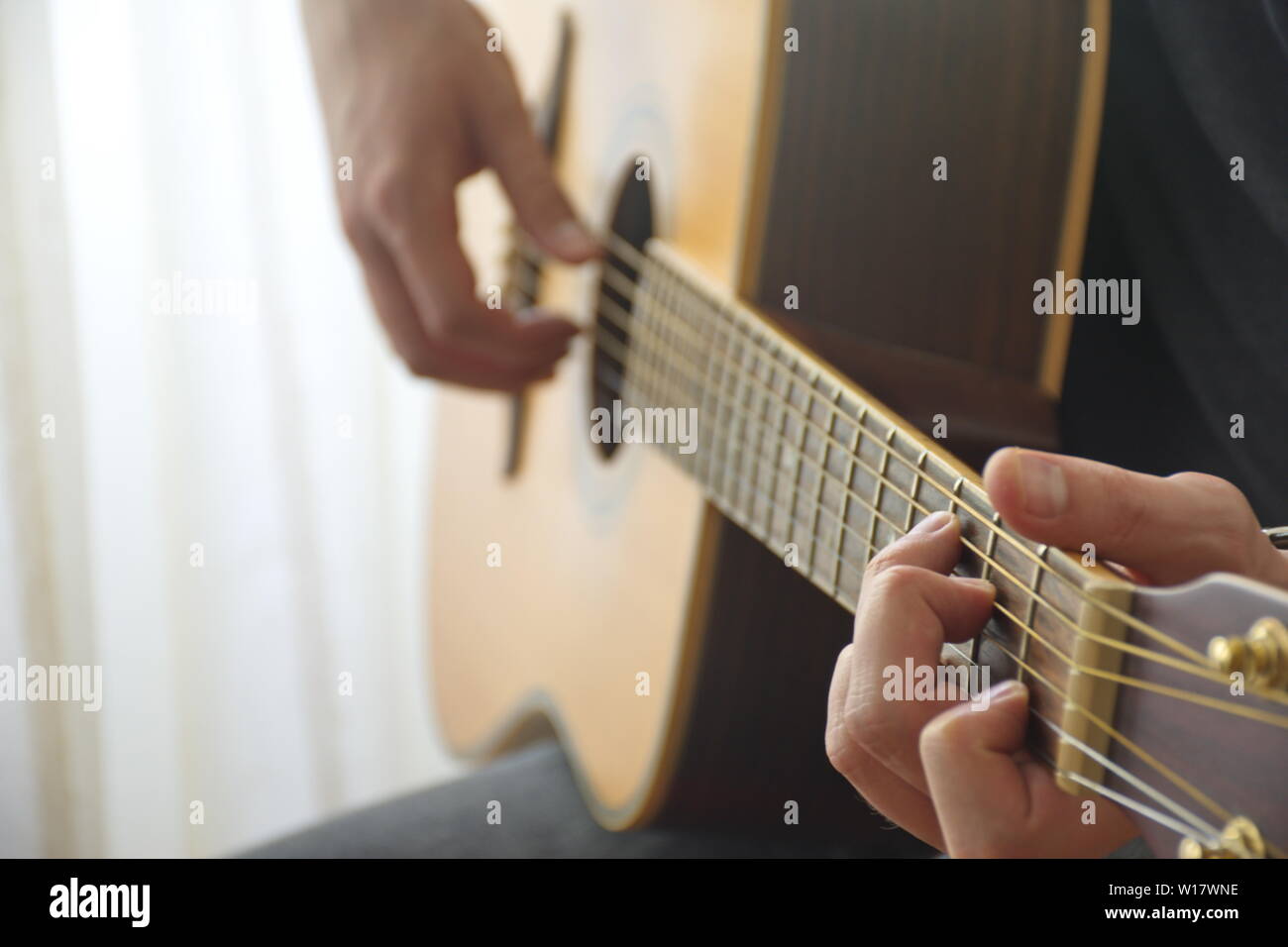 Portrait du jeune homme jouant de la guitare acoustique Banque D'Images
