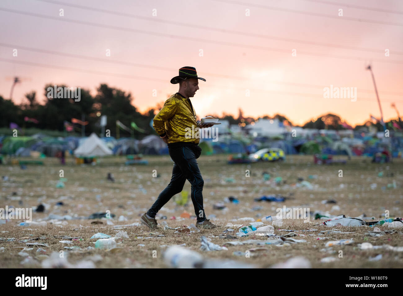 Festivaliers retourner dans leurs tentes et quitter le camp comme nettoyer commence au festival de Glastonbury à la ferme digne dans le Somerset. Banque D'Images