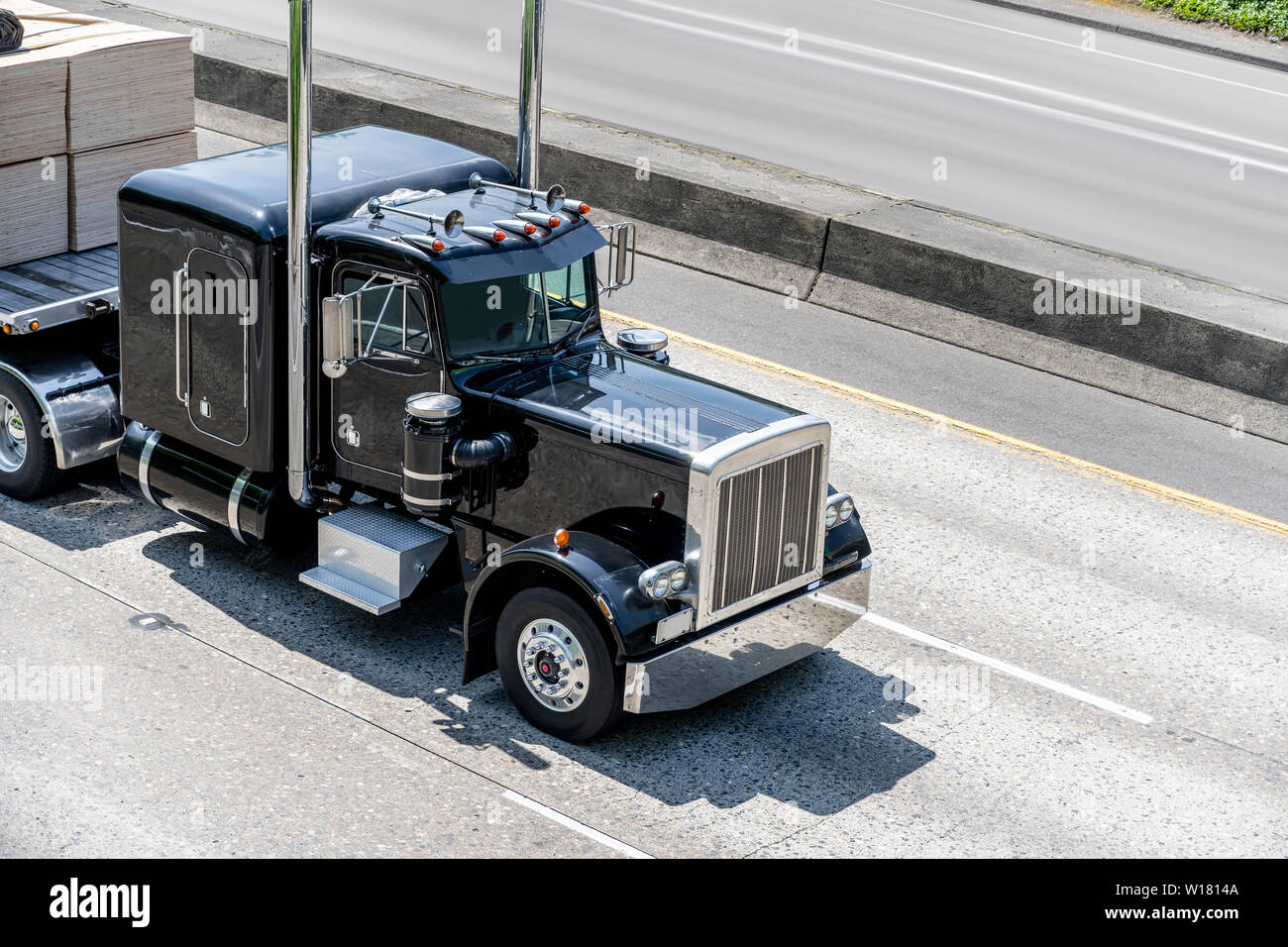 Puissant élégant noir gros camion semi industrielle classique chariot avec accessoires de chrome et des tuyaux d'échappement vertical le transport du fret sur une semi-tr Banque D'Images