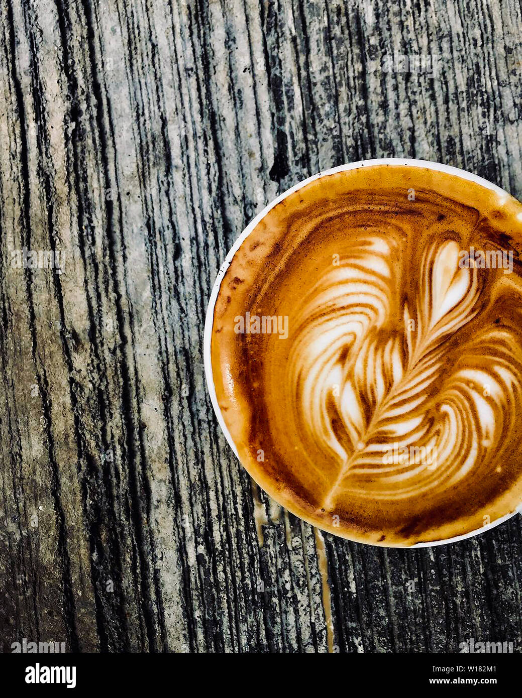 Tasse de café latte sur table en bois sombre, belle latte art Banque D'Images