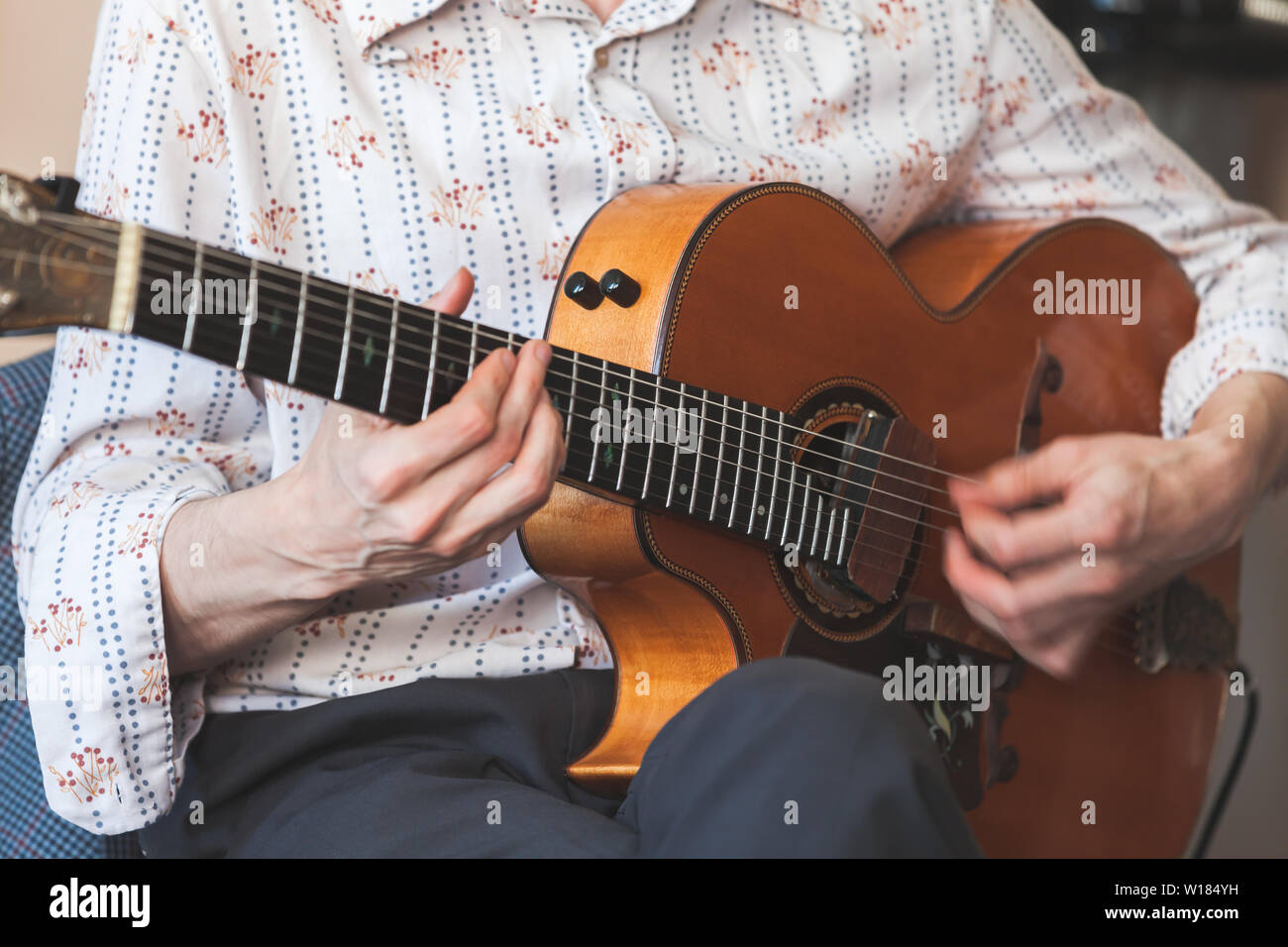Arrière-plan de la musique live. L'homme joue vintage guitare acoustique, close-up photo avec focus sélectif sur les mains Banque D'Images
