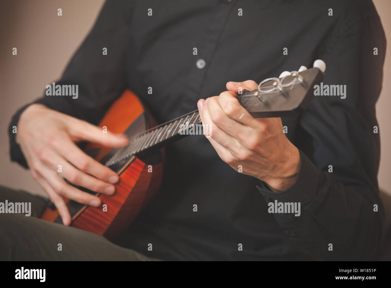 Arrière-plan de la musique folklorique russe. Mains d'un homme jouant de la balalaïka, close-up photo avec mise au point sélective et l'effet de flou de mouvement Banque D'Images
