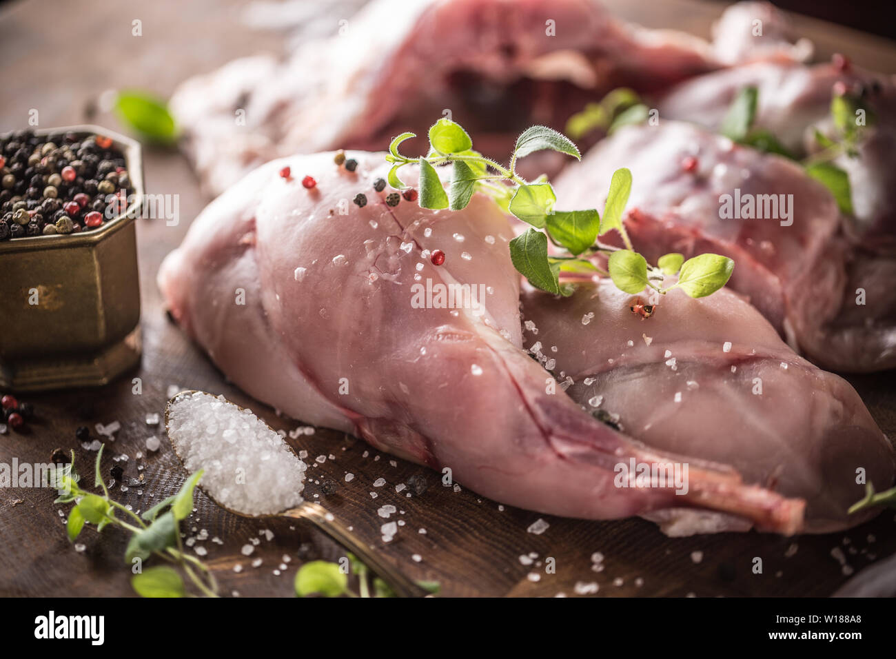 Les jambes de lapin sel poivre et herbes sur conseil de boucher Banque D'Images