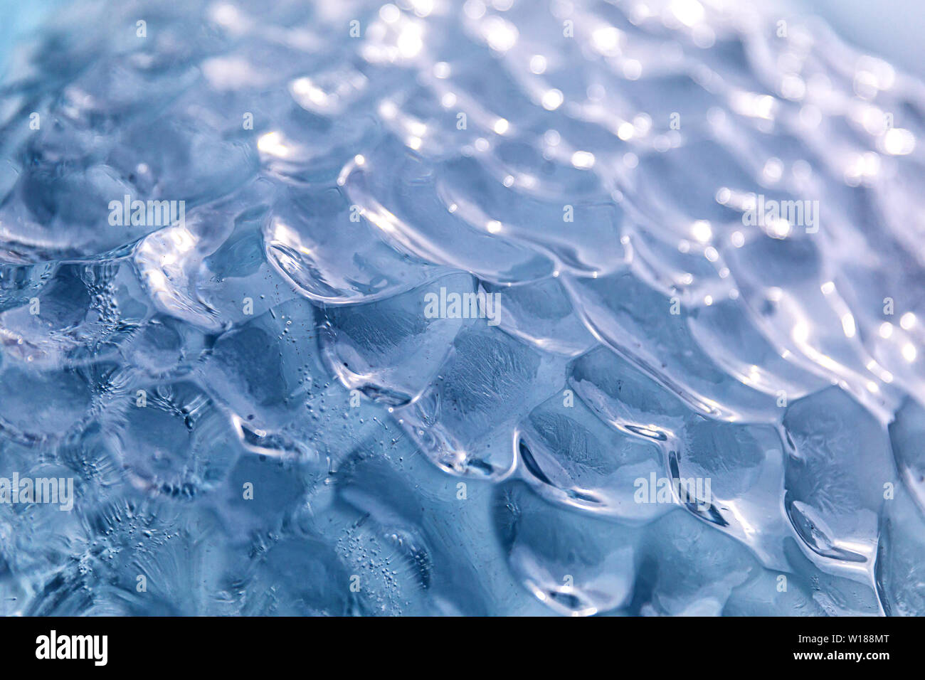 Libre de glace bleue. Un fond de glace ondulée qui fait partie d'un iceburg formé d'un vêlage des glaciers, et a l'air débordé du verre. Banque D'Images