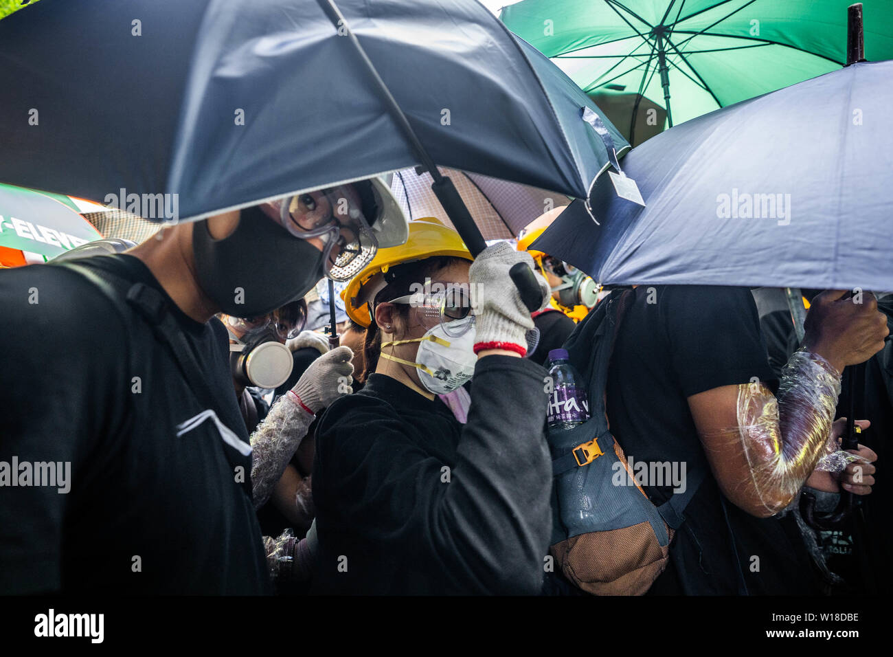 Des manifestants anti gouvernement utiliser parasols comme boucliers, ils ont également porter des engins tels demandez des masques à gaz, casques et lunettes de sécurité pour eux-mêmes la défense de jet de poivre de la police et des gaz lacrymogènes alors qu'ils tentent de prendre d'assaut le bâtiment du Conseil législatif.Des centaines de manifestants se rassemblent à l'extérieur du bâtiment du Conseil législatif et tentent de forcer le passage et occuper le parlement de Hong Kong le 1 juillet que le territoire a marqué l'anniversaire de sa 22e anniversaire rétrocession à la Chine. Banque D'Images