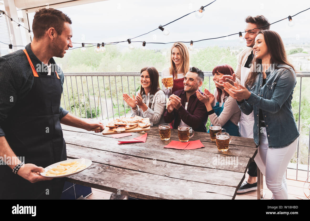Groupe d'amis heureux de boire une bière et manger une pizza à la brasserie bar restaurant. concept avec des jeunes ayant un véritable plaisir Banque D'Images