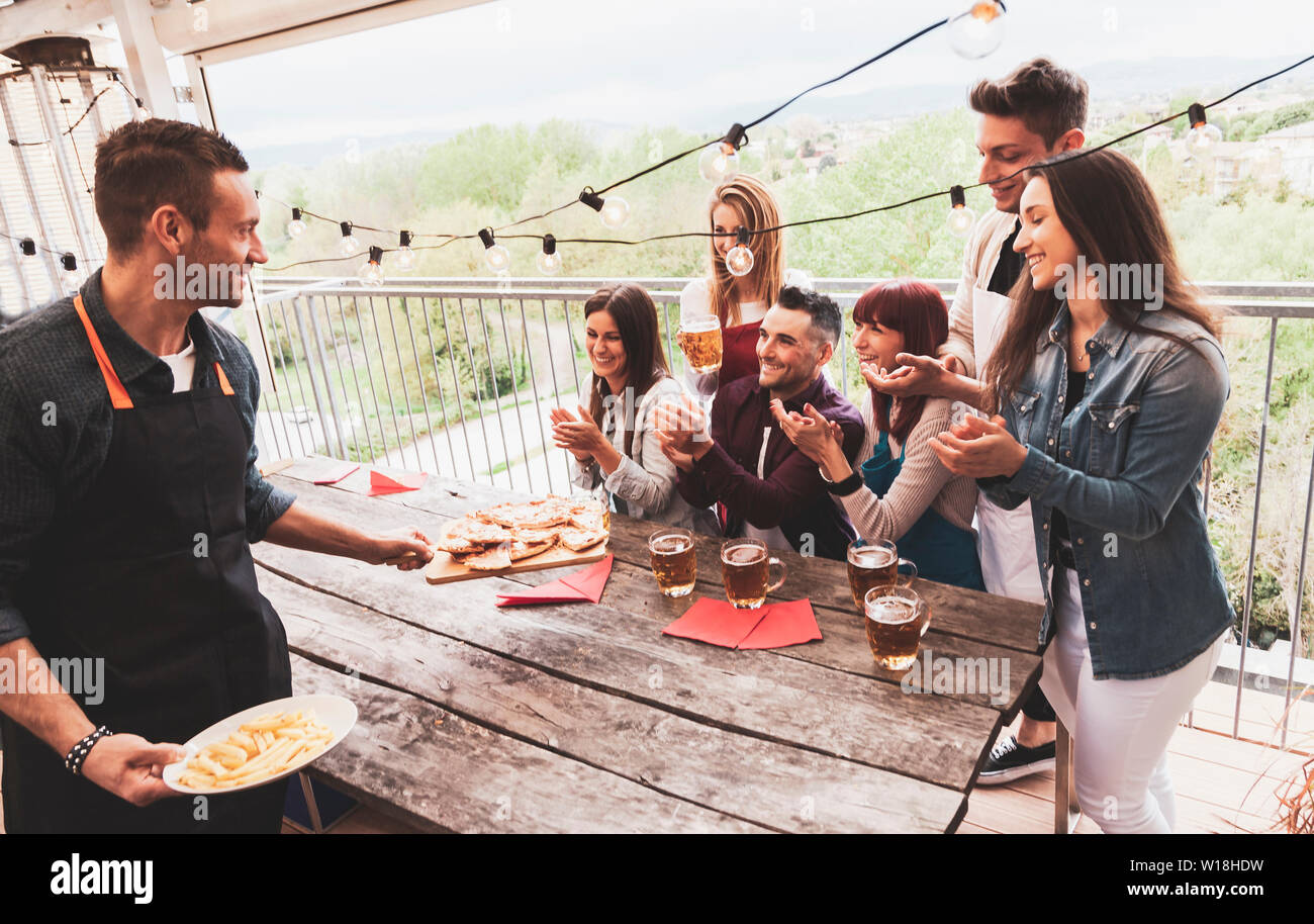 Groupe d'amis heureux de boire une bière et manger une pizza à la brasserie bar restaurant. concept avec des jeunes ayant un véritable plaisir Banque D'Images