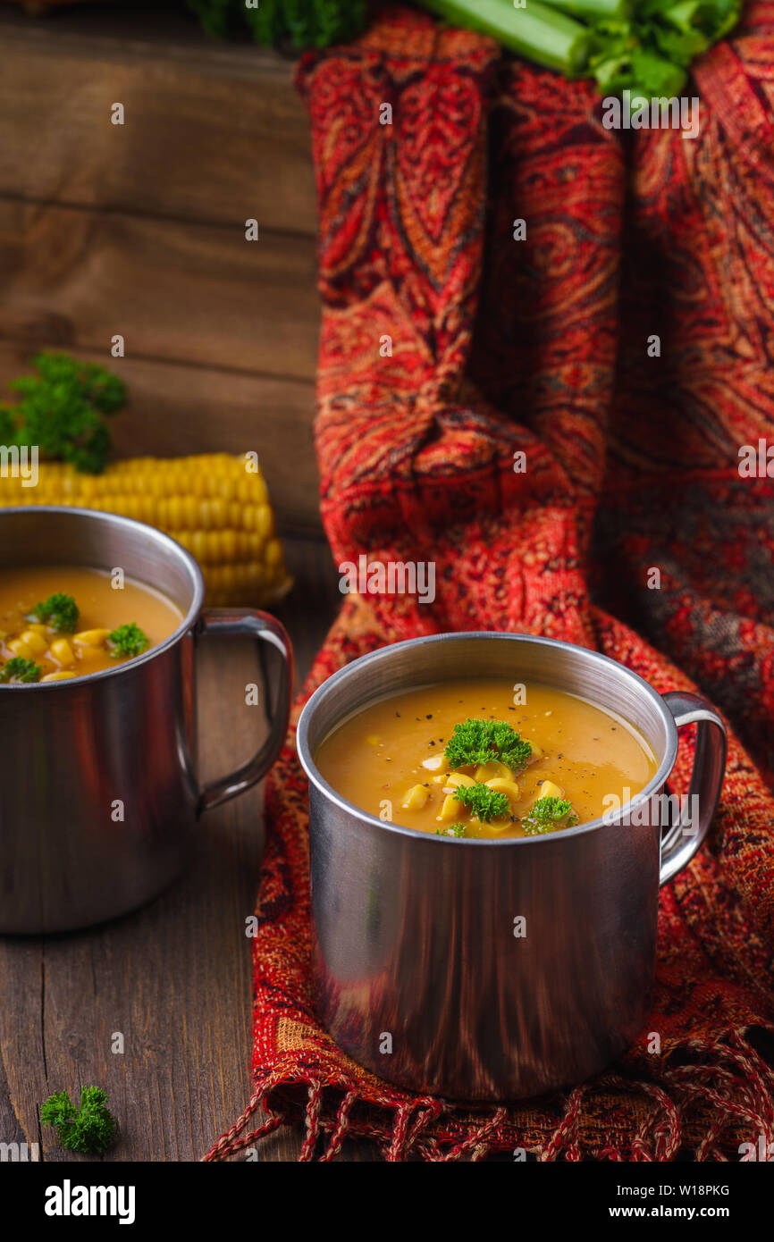 Une tasse de soupe au potiron servi avec le maïs et le persil. Le déjeuner d'automne sain concept Banque D'Images
