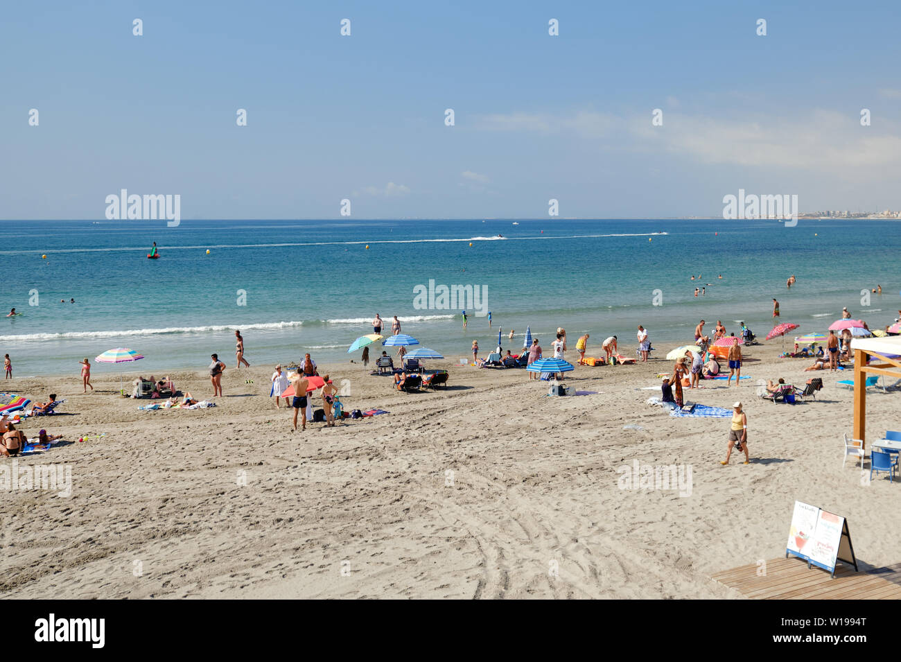 Torrevieja, Espagne - 25 juin 2019 : Les vacanciers l'été locations de vacances en bord de mer près de Mer Méditerranée de Cabo Roig côte sableuse, sunb Banque D'Images