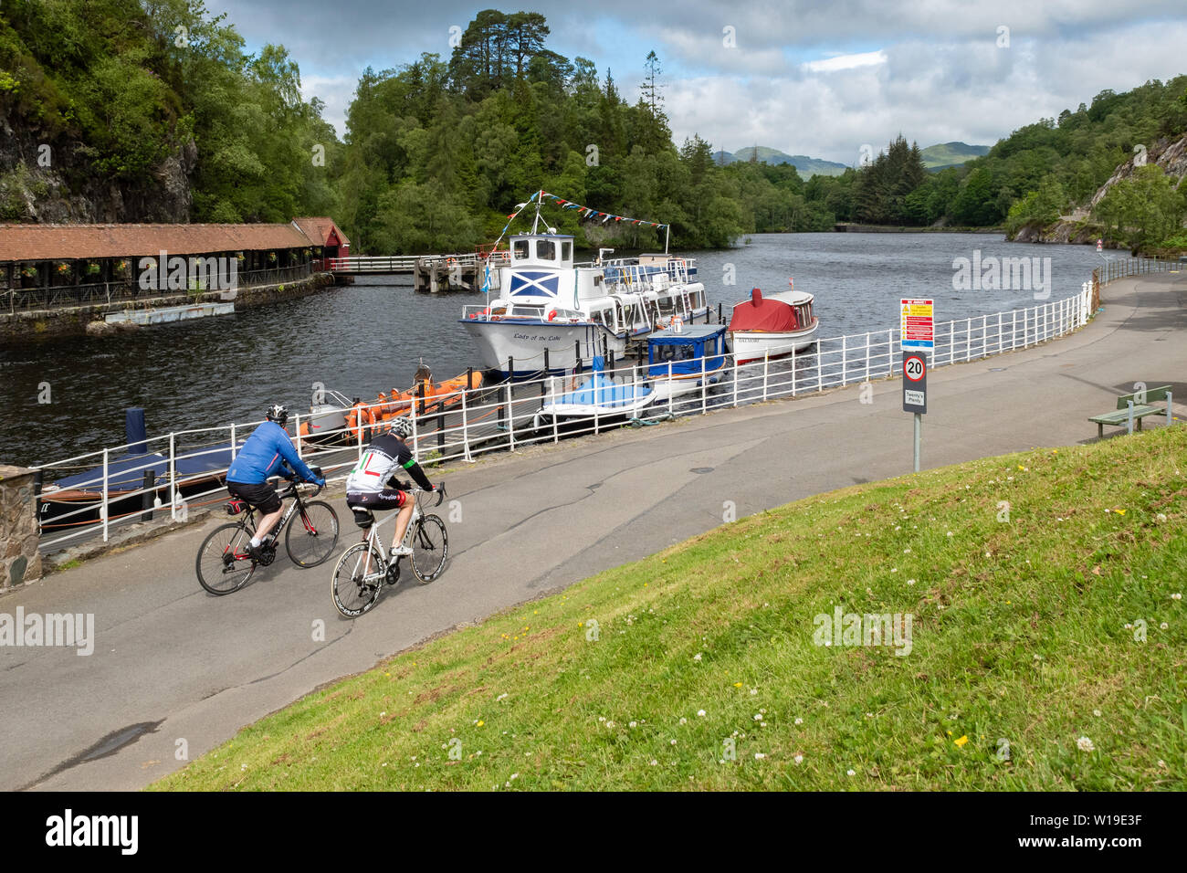 Trossachs Pier, Loch Katrine, Scotland, UK - les cyclistes passant la Dame du lac en bateau de croisière Banque D'Images