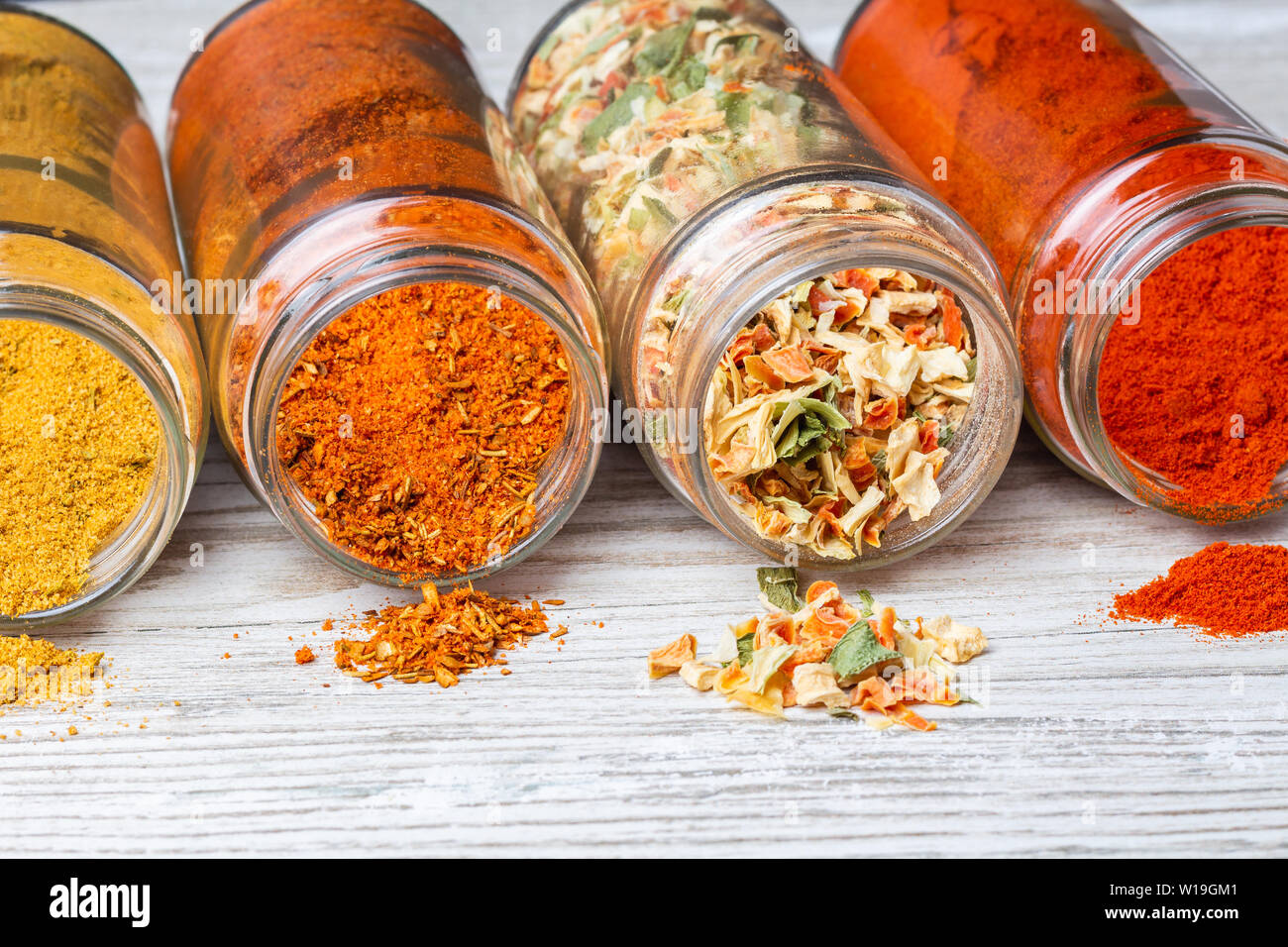 Épices en versant des pots allongé sur un comptoir en bois. de légumes, rez-de paprika, curry et mélanges d'épices. Banque D'Images