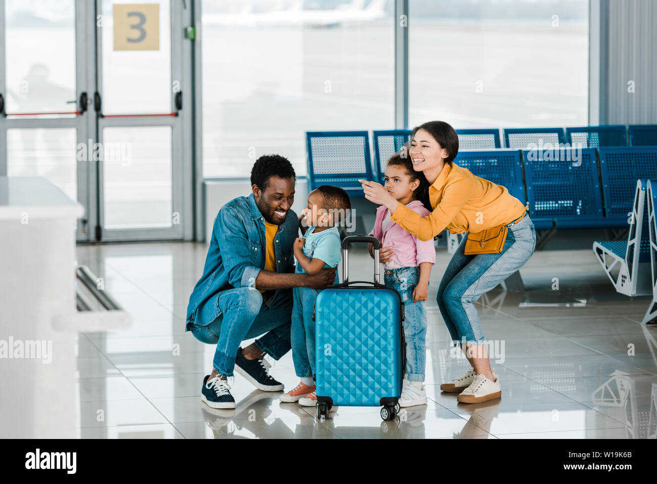 Smiling african american family avec les bagages et les enfants in airport Banque D'Images