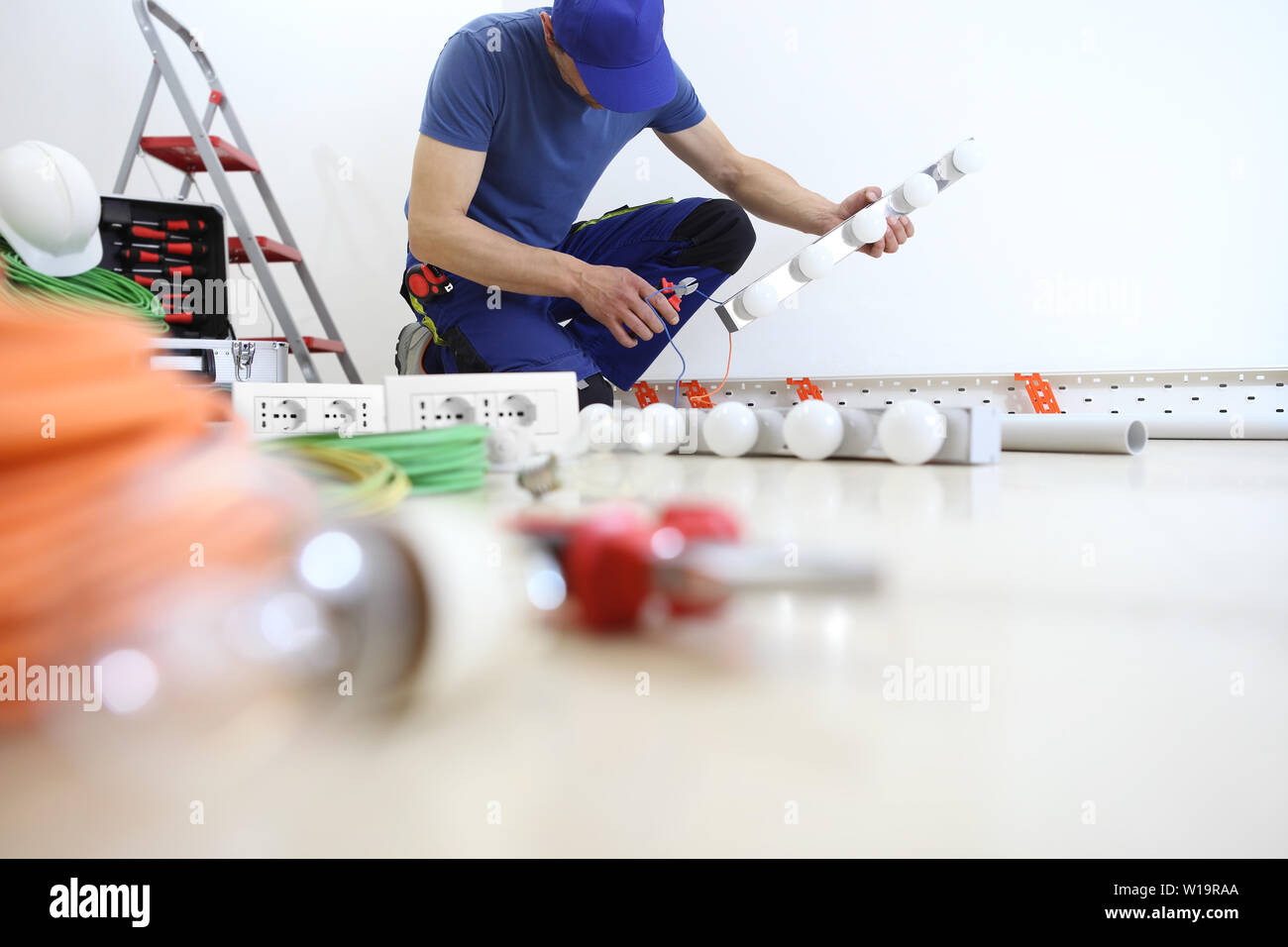 Électricien au travail des tenailles dans la main couper le câble électrique, lampes à poser, les circuits électriques, câblage électrique Banque D'Images