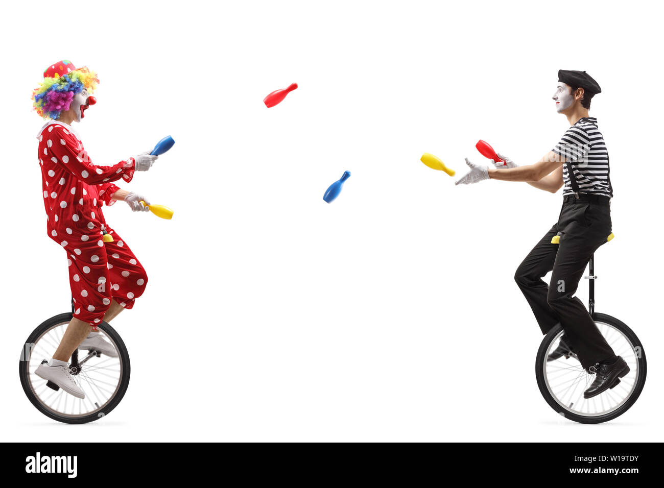 De toute la longueur d'un mime et clown sur monocycles juggling clubs avec isolé sur fond blanc Banque D'Images