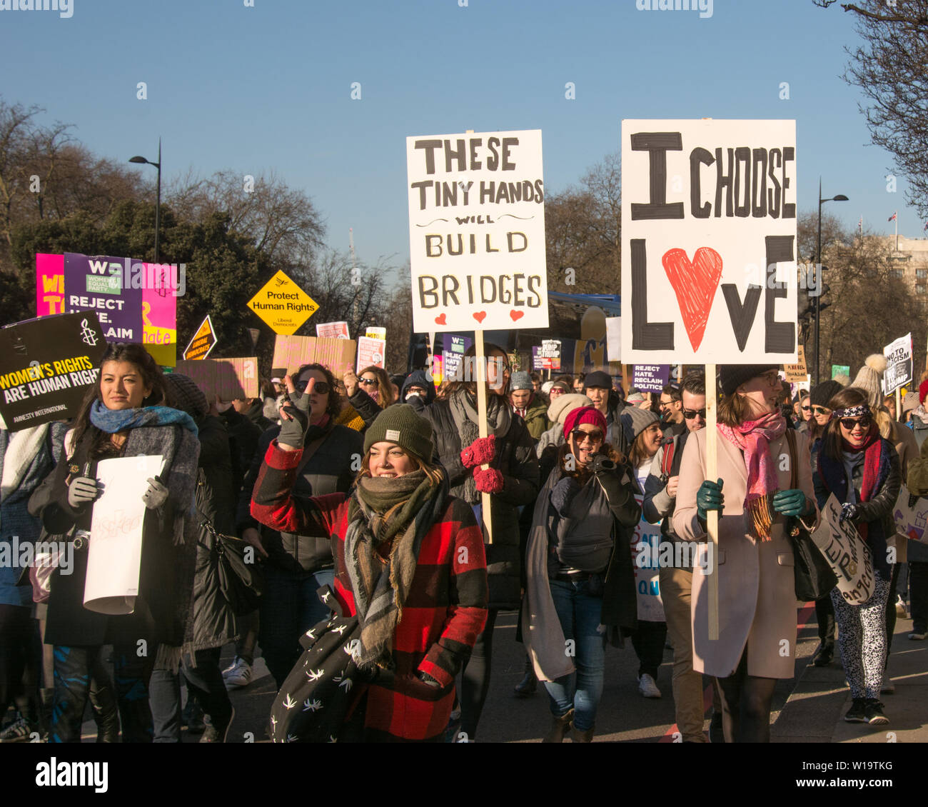 La Marche des femmes, Londres, Royaume-Uni, 21 janvier 2017. Une femme porte un écriteau qui dit 'Je choisis l'amour' à Londres pour protester contre le jour après l'investiture du président Donald Trump. Jusqu'à 10 000 ont pris part à Londres en tant que femmes dans le monde ont marqué la journée en marchant dans un acte de solidarité internationale. Un autre manifestant porte un écriteau qui dit "Ces petites mains vont construire des ponts". Banque D'Images
