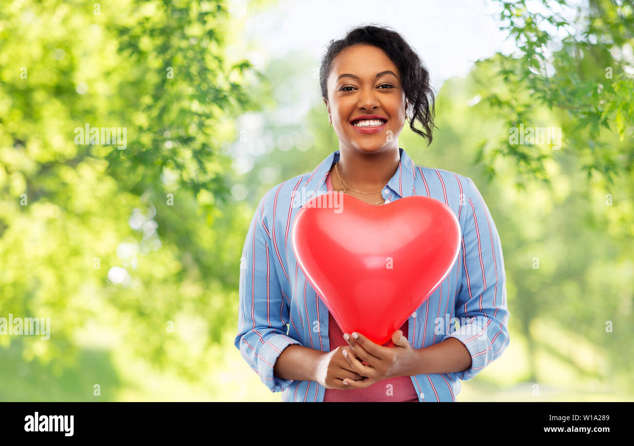 African American Woman with heart-shaped balloon Banque D'Images