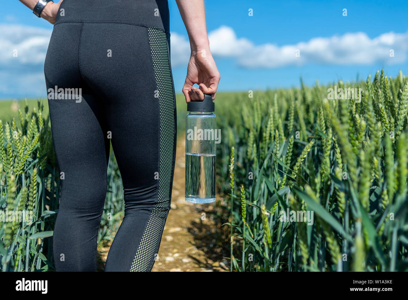 Bouteille d'eau en verre. Gros plan d'une femme sportive portant une bouteille d'eau. Banque D'Images